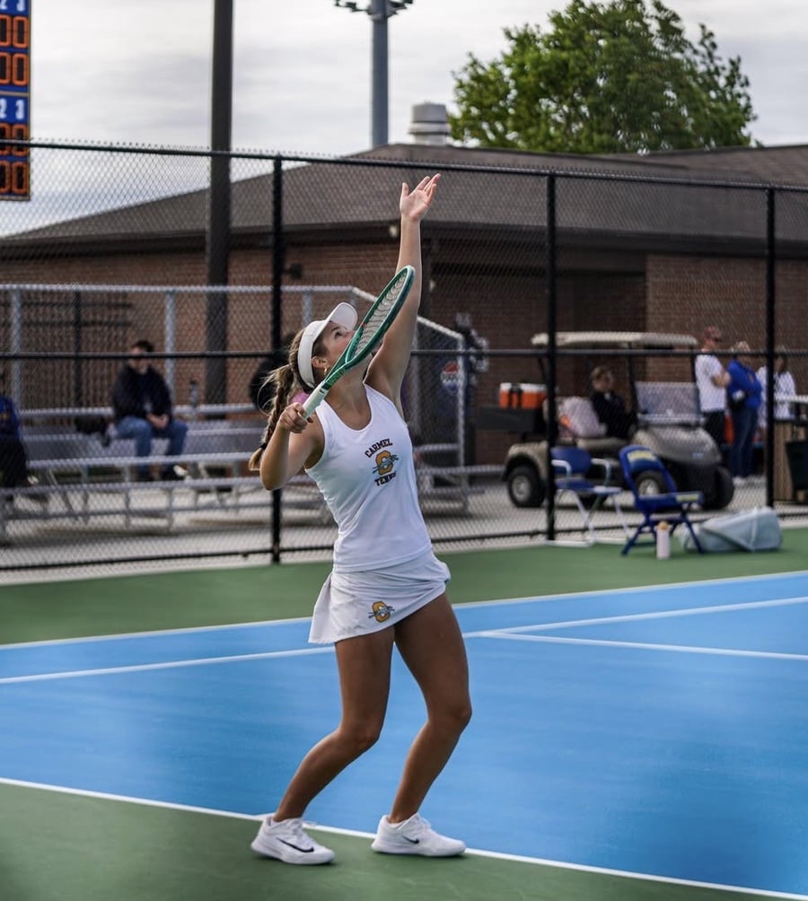Annie Mann serving during a tennis match